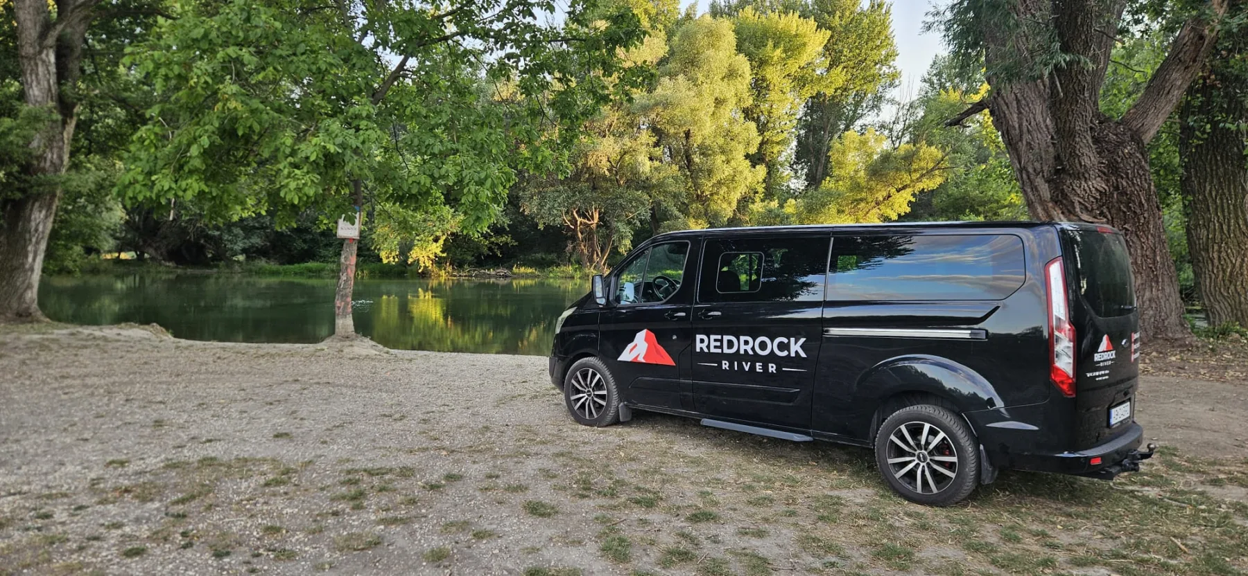 Čierne vozidlo Red Rock River zaparkované pri nástupnom mieste na rieke